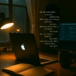 Không gian xây dựng website cá nhân xuyên đêm – ánh đèn vàng, laptop mở, bên ngoài mưa rơi lặng lẽ